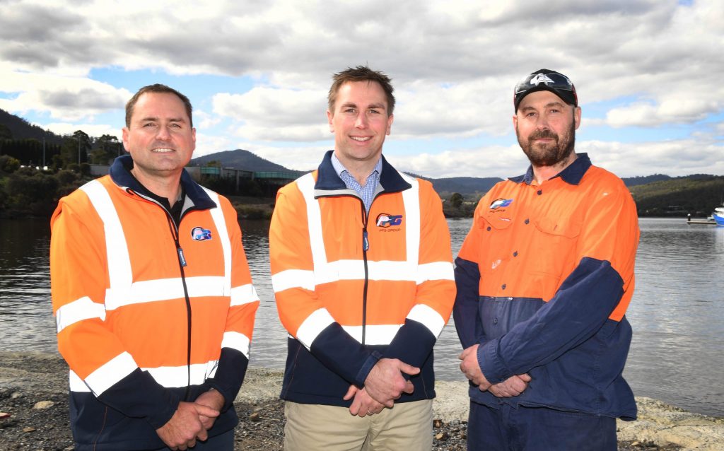 Three Hobart boat builders standing by the water smiling.